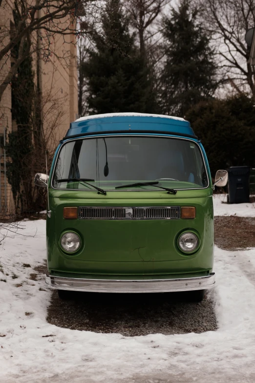 a small green van is parked on the snow