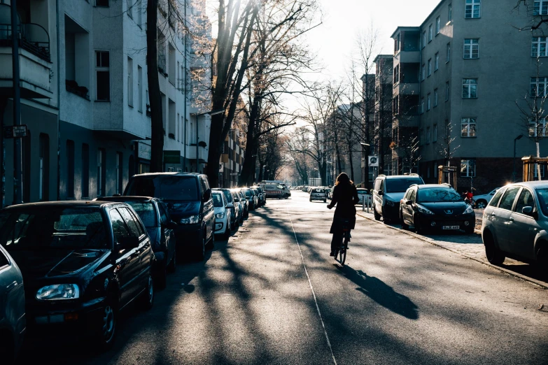 person walking down street in front of cars