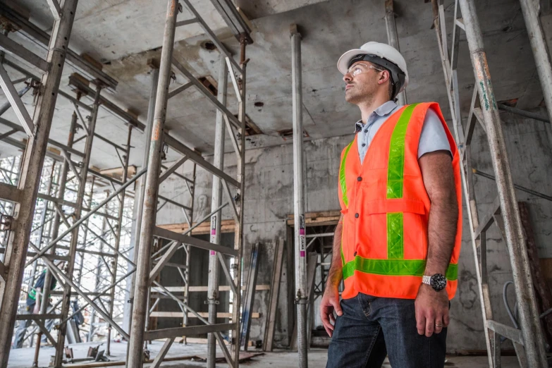 a construction worker standing next to scaffolding in a large building