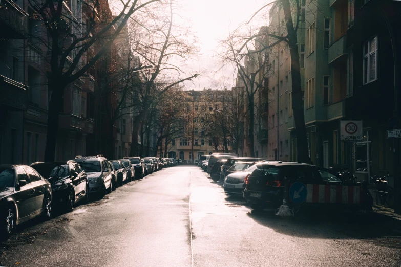 a street scene with cars parked on the side and one car behind it