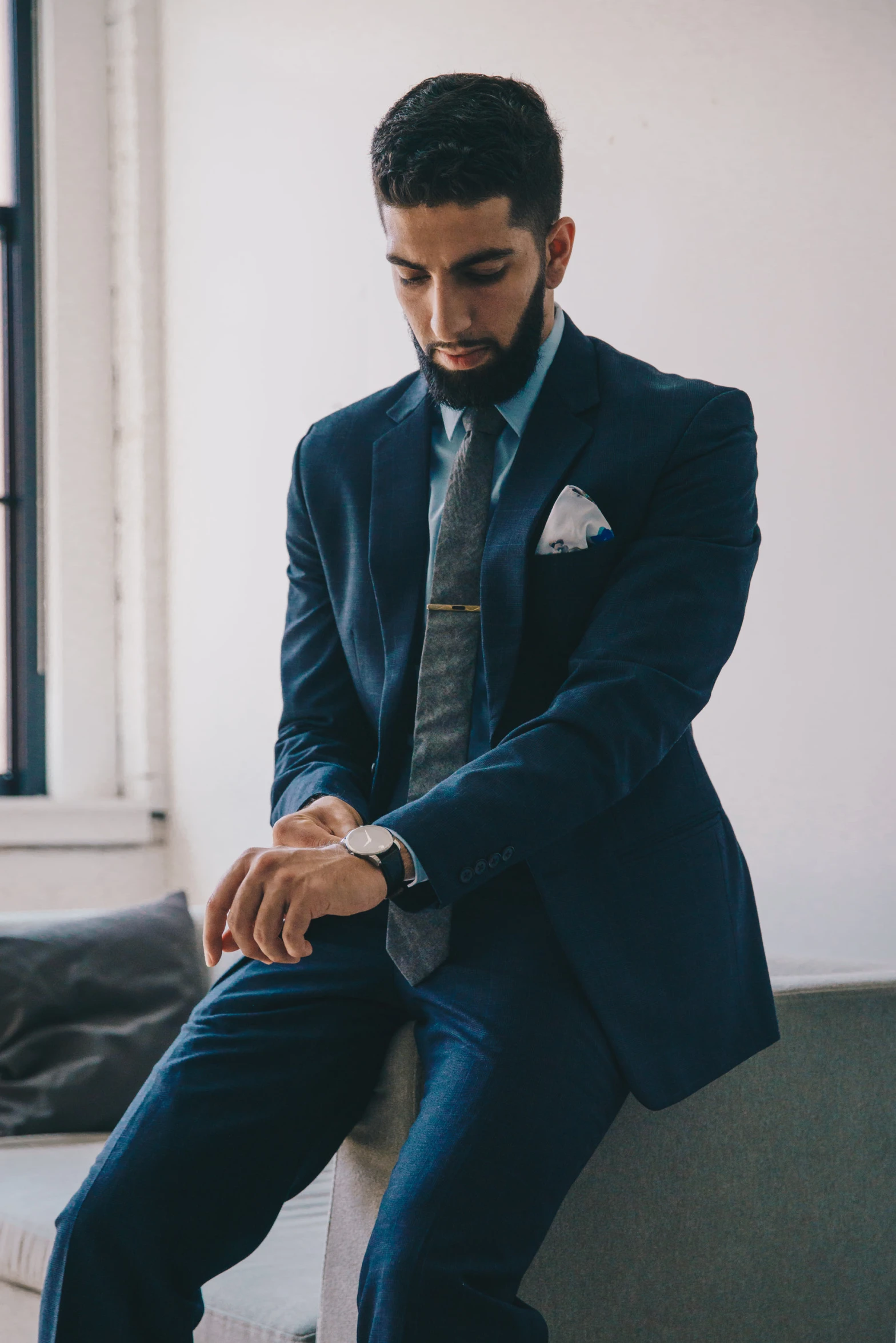 a man is sitting on a wall, dressed in a suit and tie