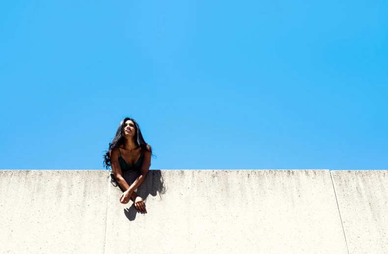 a women who is sitting on the ledge