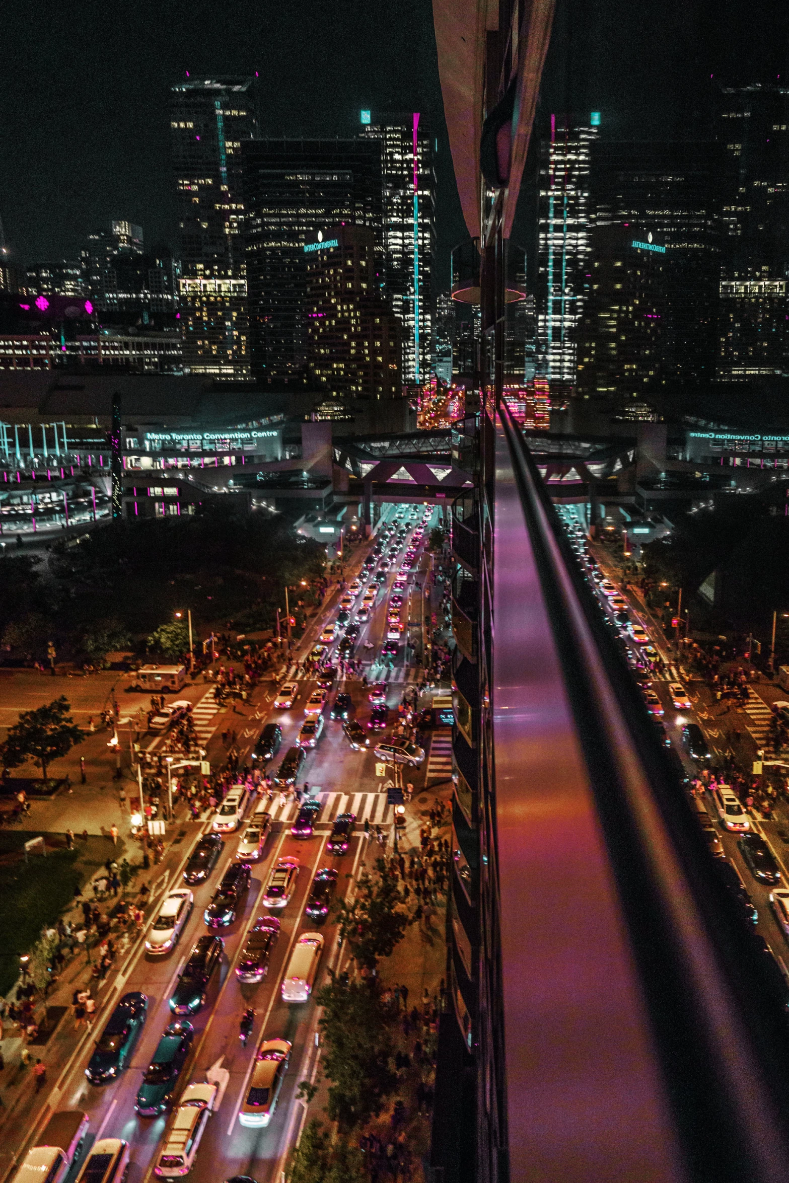 a cityscape at night filled with traffic and lots of tall buildings