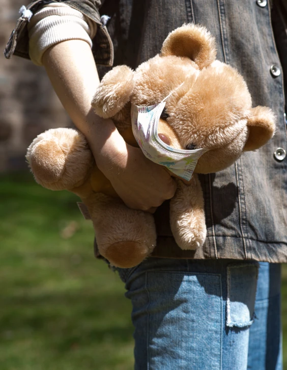 the girl is holding two teddy bears in her hands