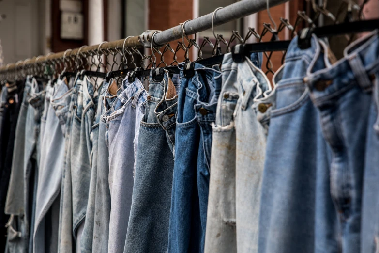 several pairs of jean pants hanging on a line