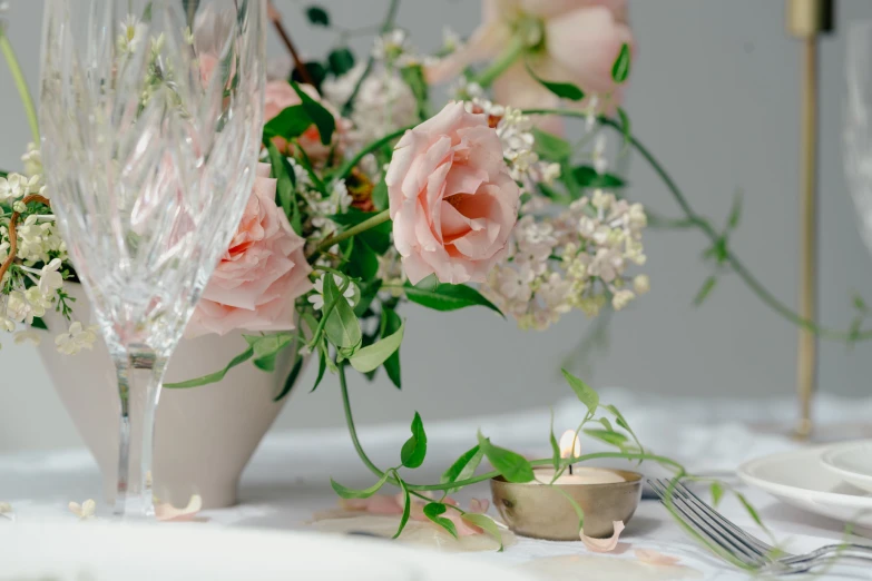 a vase with flowers sitting next to a glass