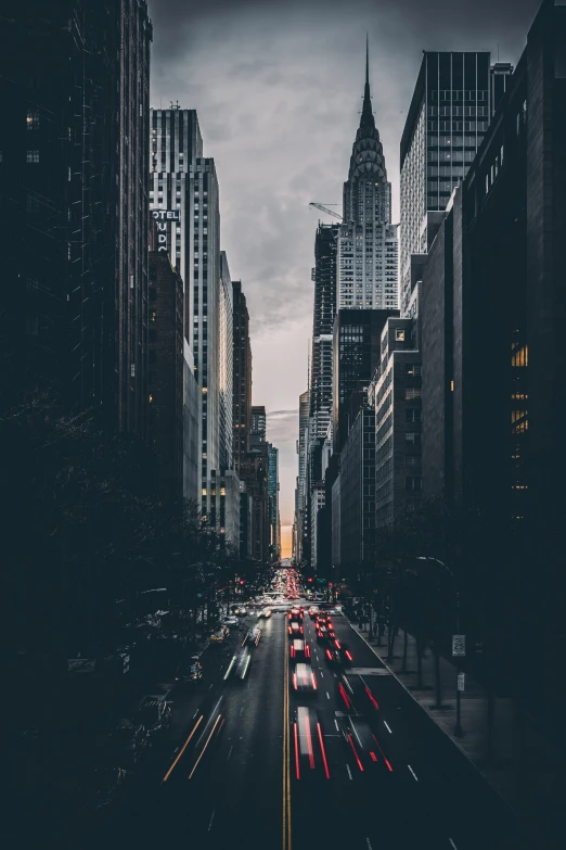 city street with tall buildings and vehicles with headlights