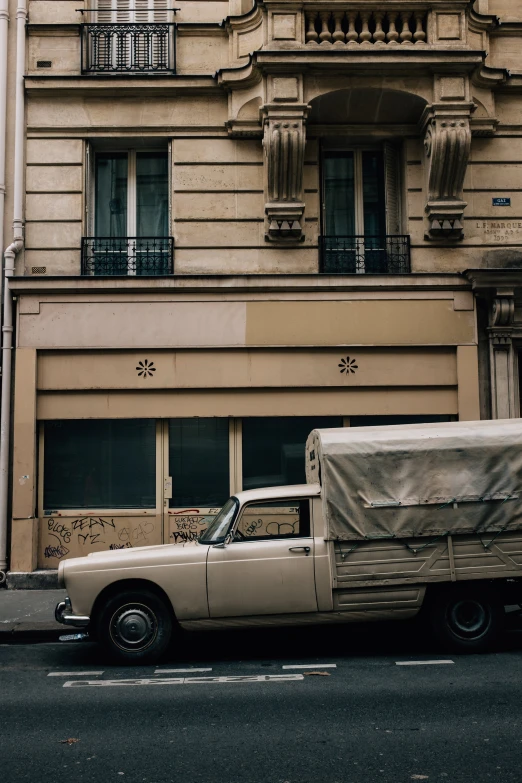 an old truck is parked by the curb