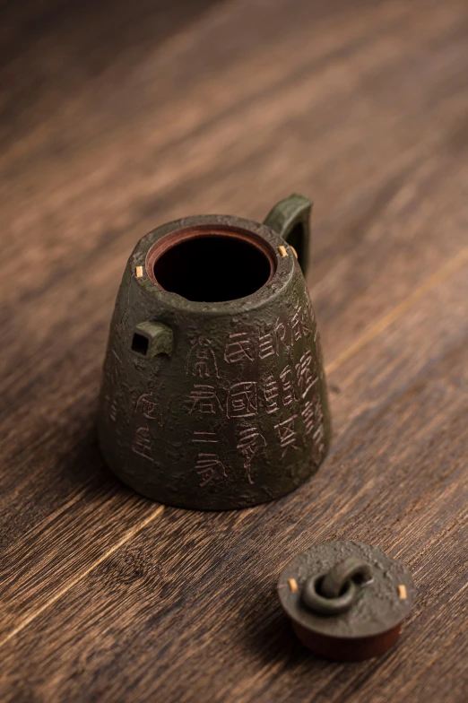 the pottery is on the wood surface near the bottle