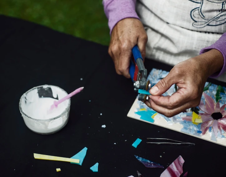 a woman with blue nails is holding a toothbrush and a small bowl