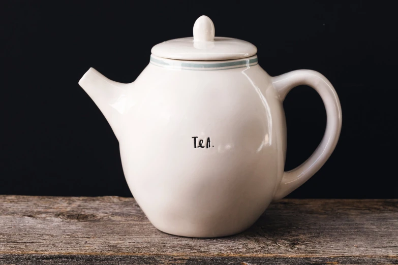 a white ceramic tea pot with a glass cover