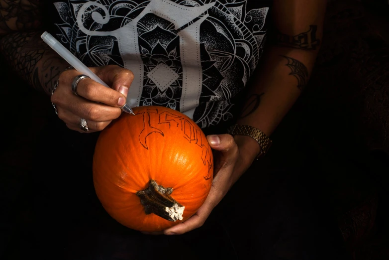 a woman holding an orange while holding a cigarette