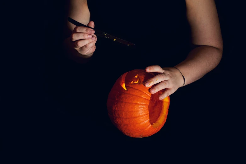 someone holding onto a pumpkin in their hands