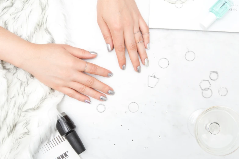 a woman holding onto her nails sitting next to other things