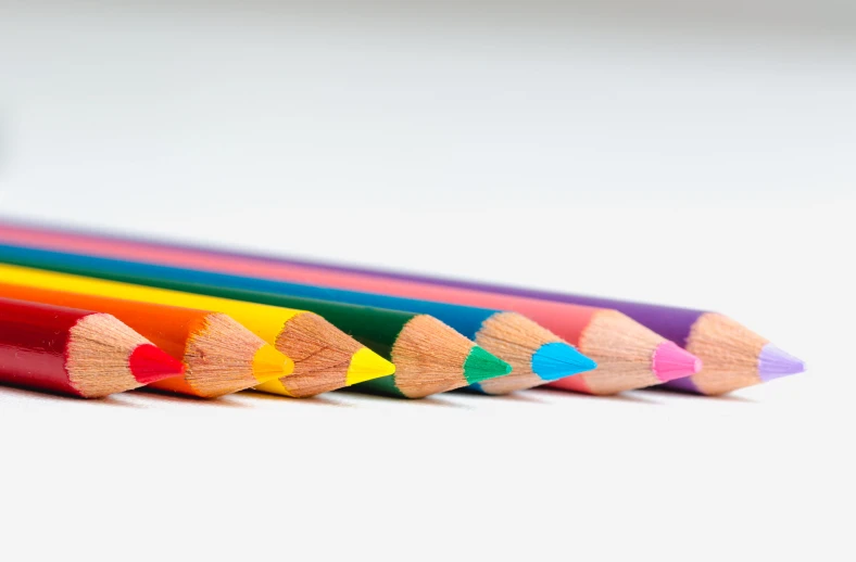 a close up of a row of colored pencils