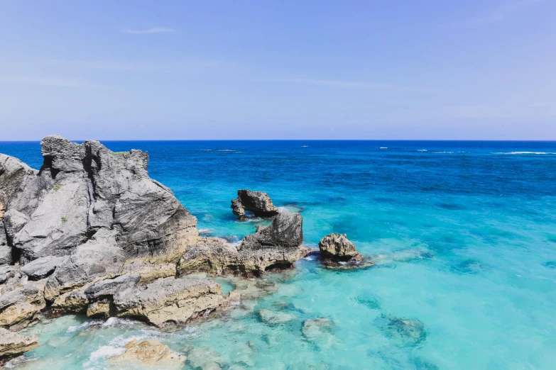 the water has clear blue and turquoise and is next to large rocks