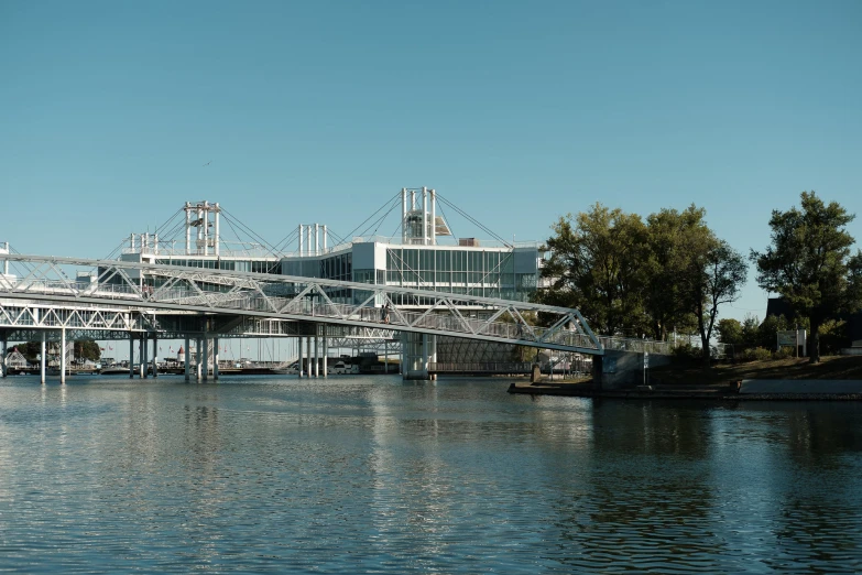 a bridge over water that is connected to two large buildings