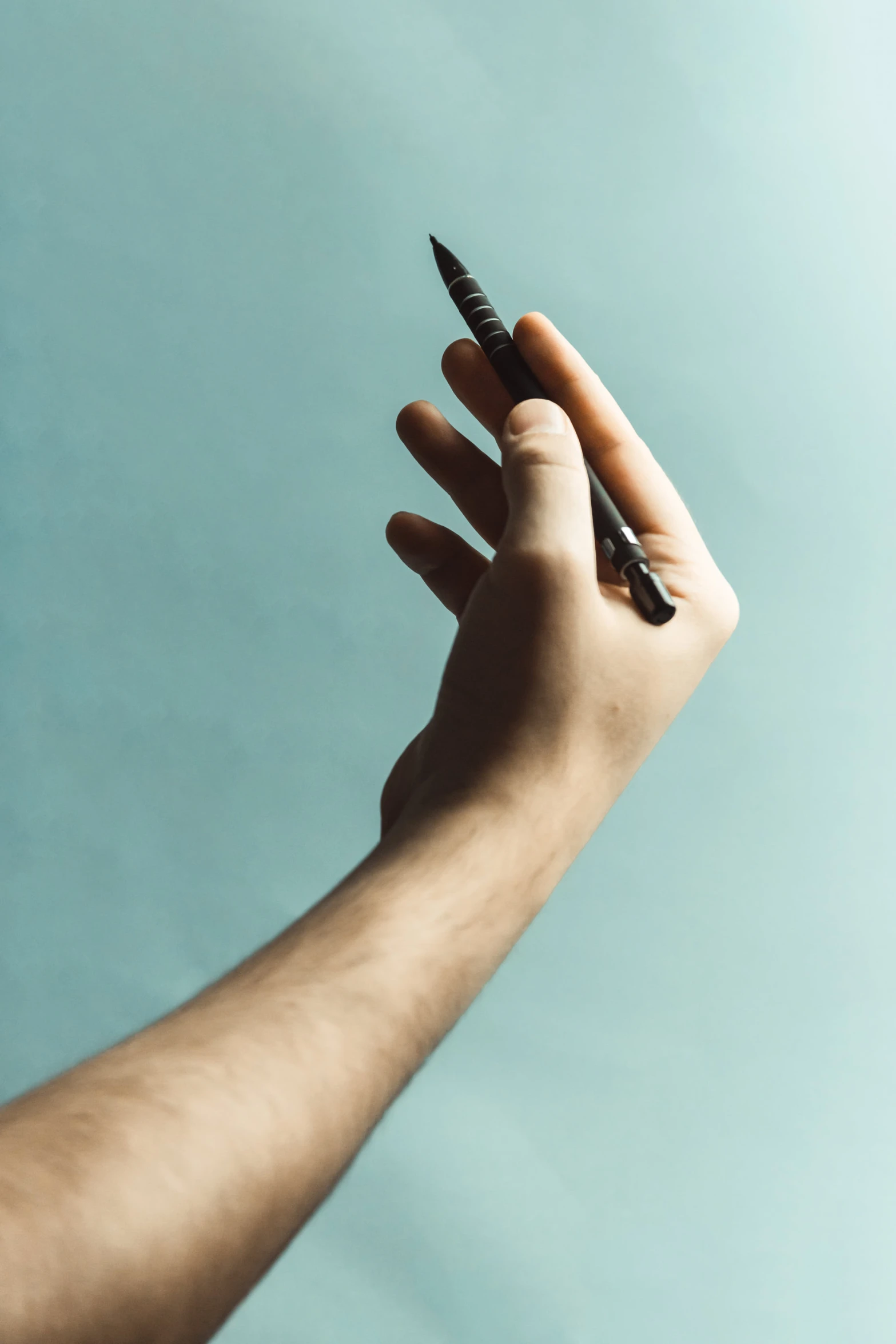 the hand holds a black pen in it's palm