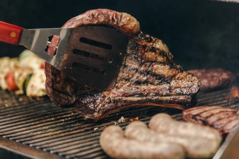 a steak is being prepared on the grill with other food items