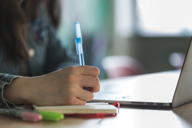 a close up of a person writing on a laptop