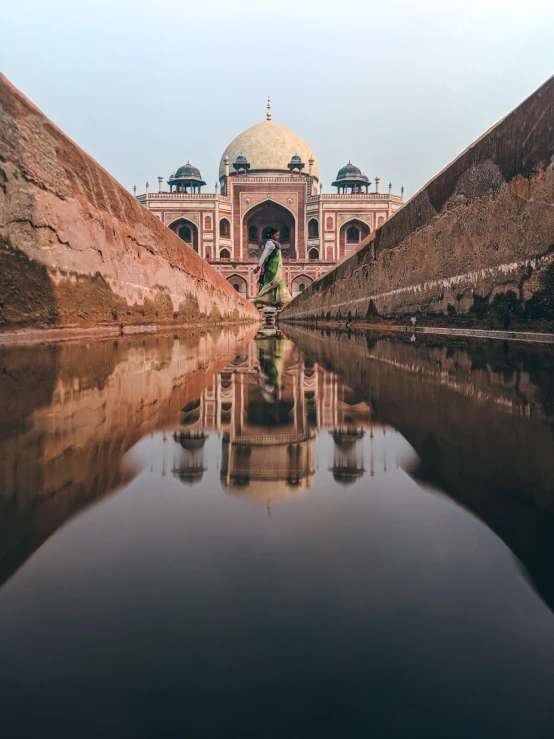 a building with an ornate design is reflected in water