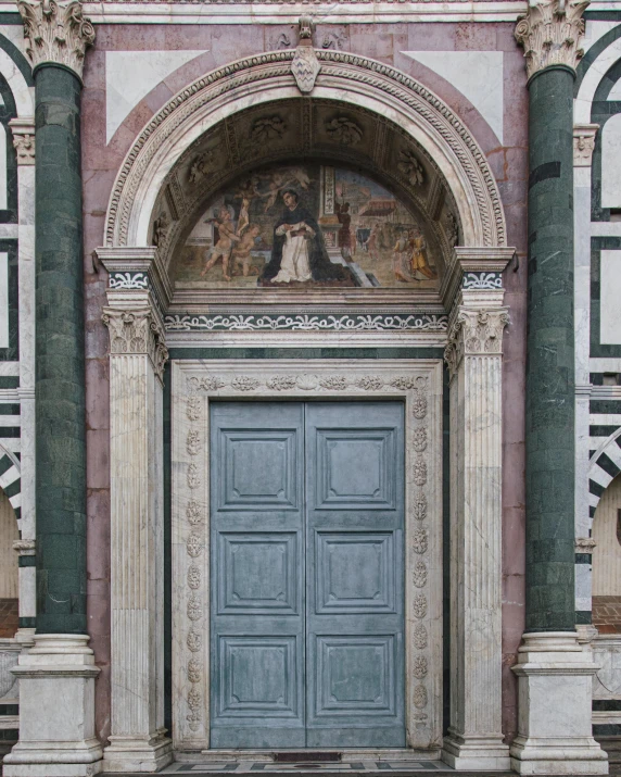 a door with carvings on it is surrounded by statues