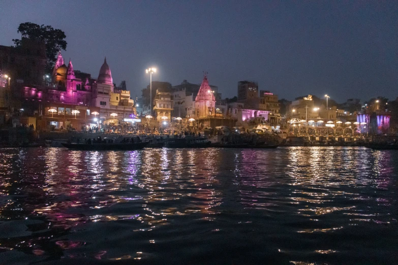 a lit up town is beside the river