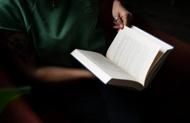 a person is sitting on the red couch reading