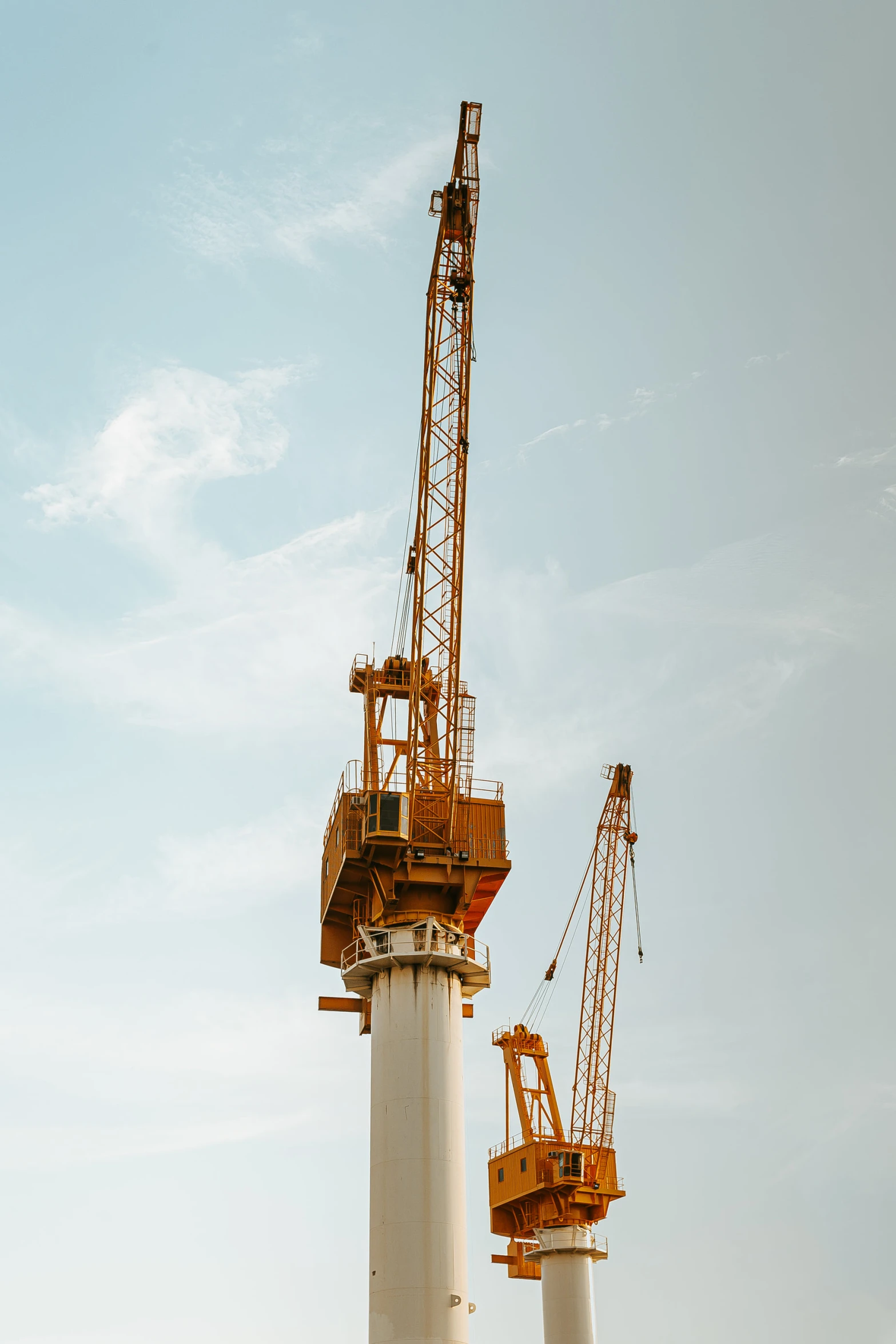 two cranes are seen standing near the structure