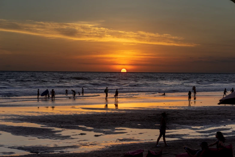 several people are enjoying the sunset at the beach