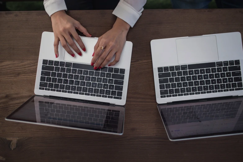 two people using their laptops on a table