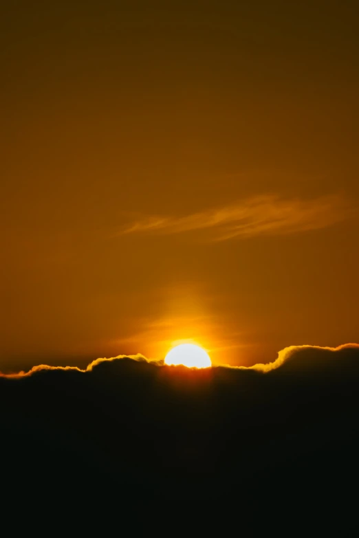 a bright sun is seen through clouds and the sky