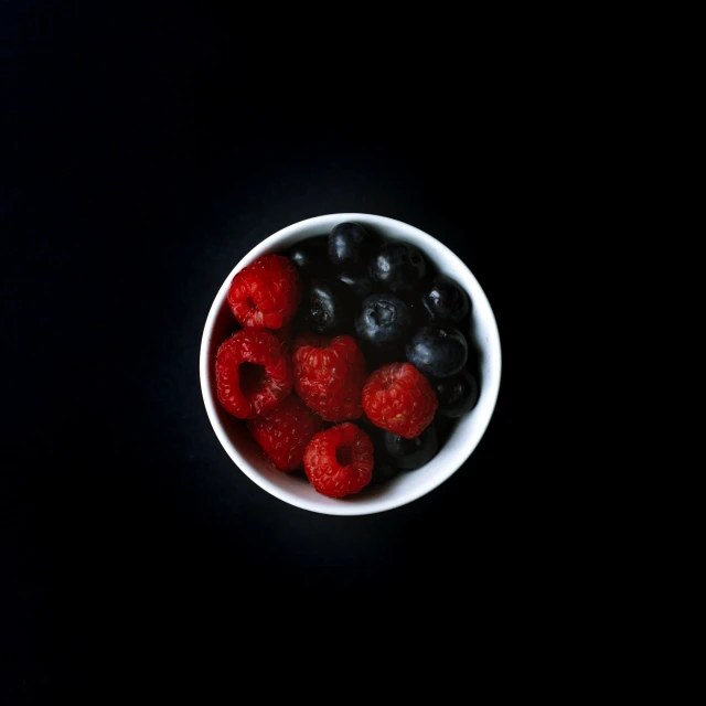 a bowl with berries and blueberries in it
