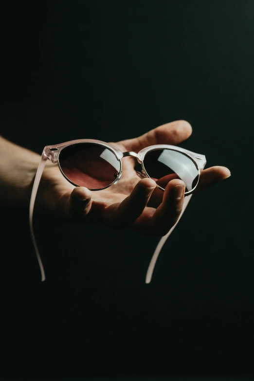 the reflection of a pair of sunglasses in a hand