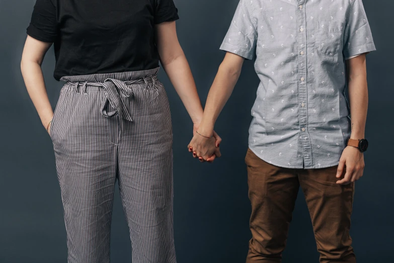 a couple standing holding hands while posing for a picture