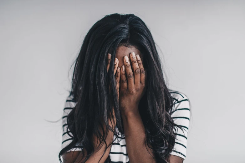 a woman covering her face with her hands