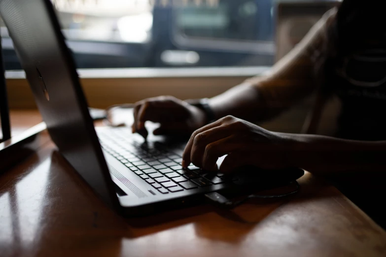 the man uses his laptop on a table