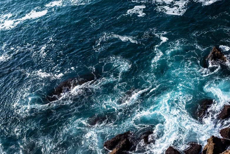 a view of some waves in the ocean from above