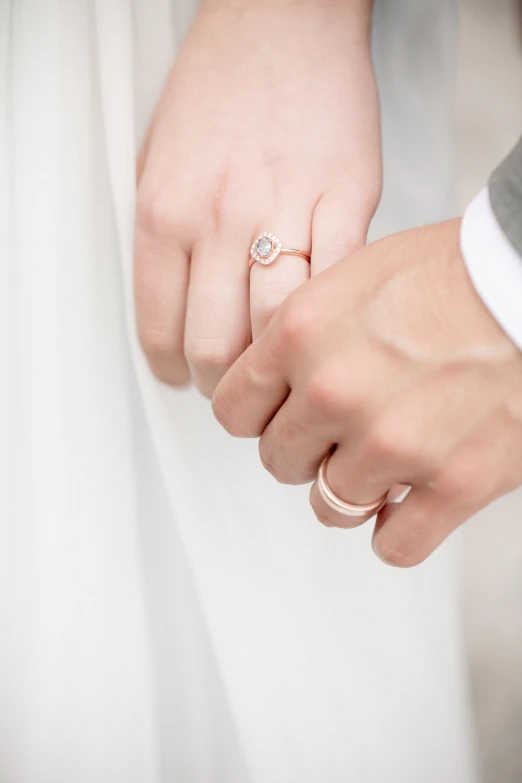 two people holding hands and wearing wedding rings