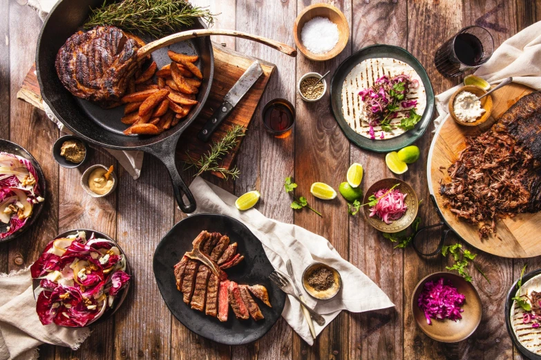 barbecue and sides are on the table next to some bread