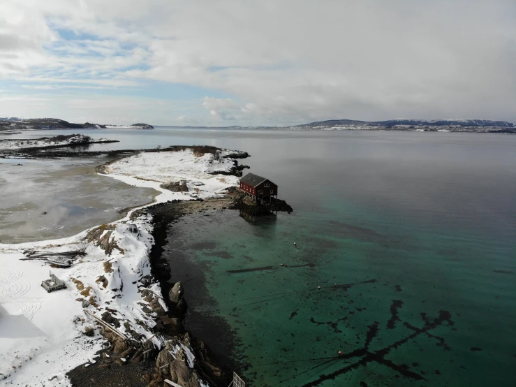 a snow covered rocky shoreline surrounded by ocean