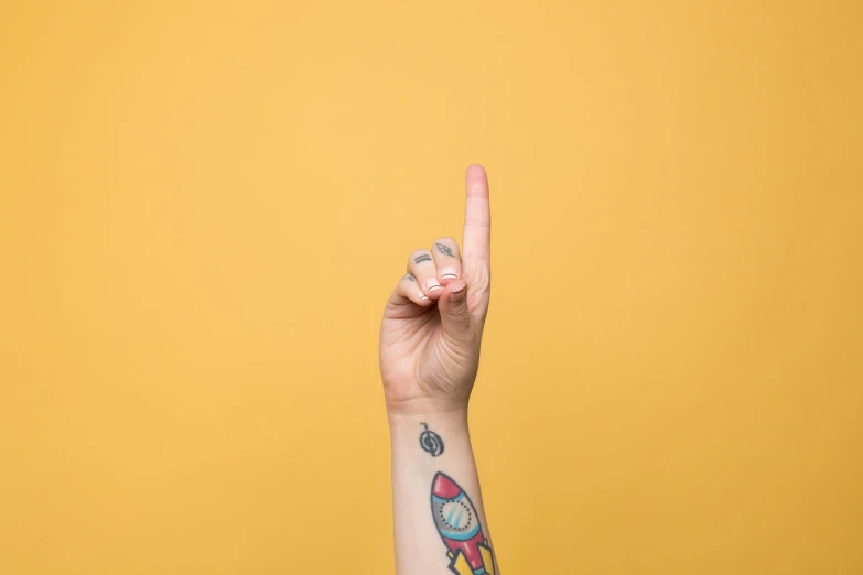 a person holding up a peace sign and wearing a colorful wristband