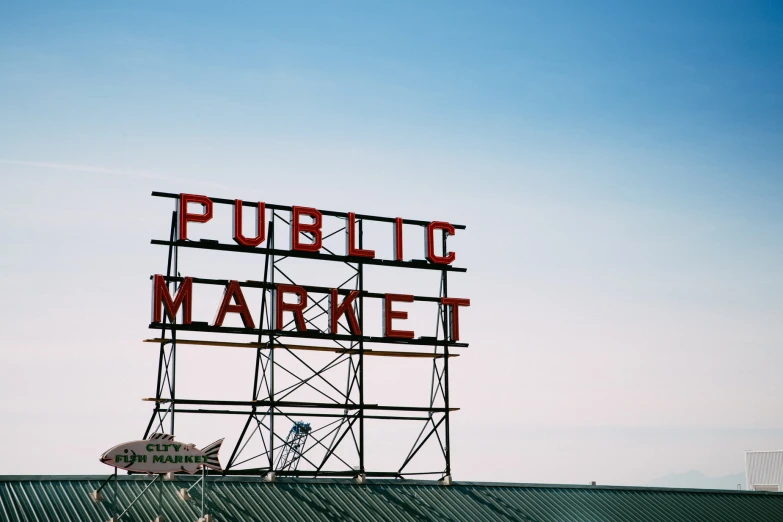 a large red public market sign on top of a metal building