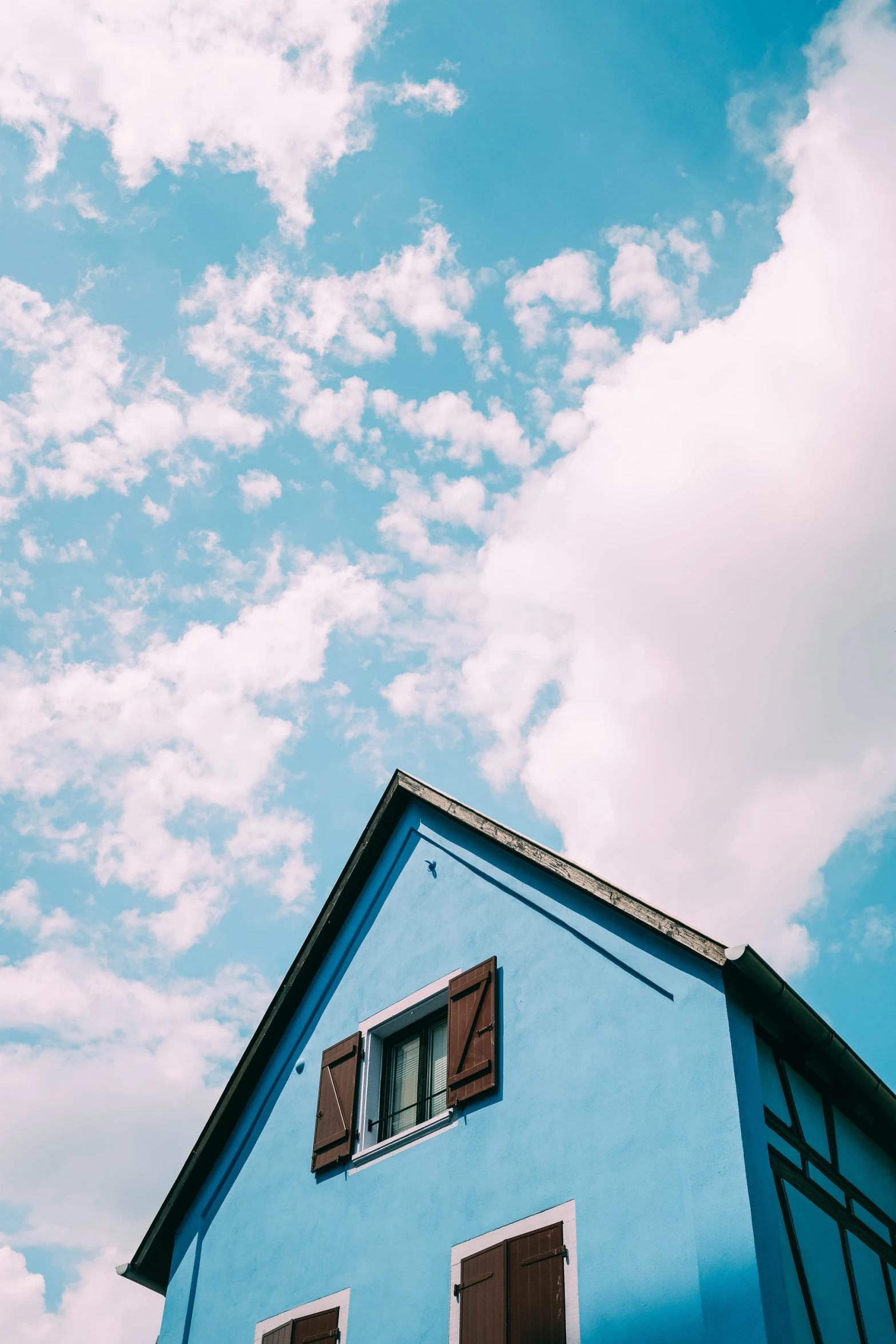 a blue house with two brown shutters on it