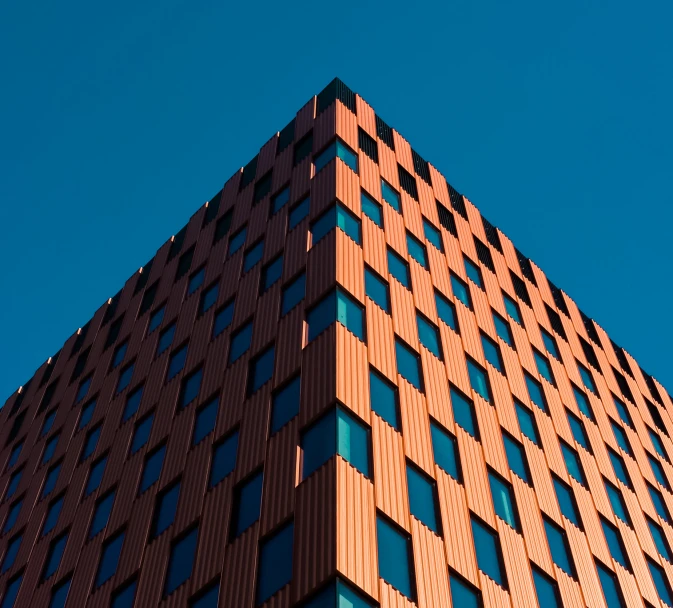 an upward view of the corner of a large building with some windows