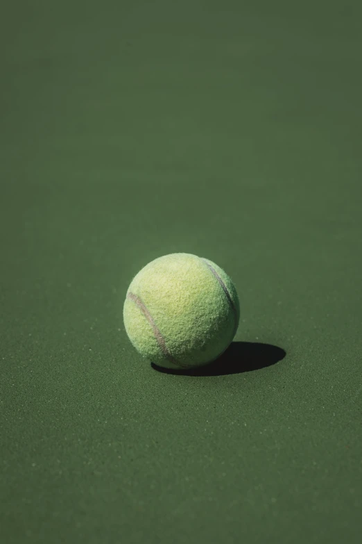 a tennis ball that is sitting on the ground