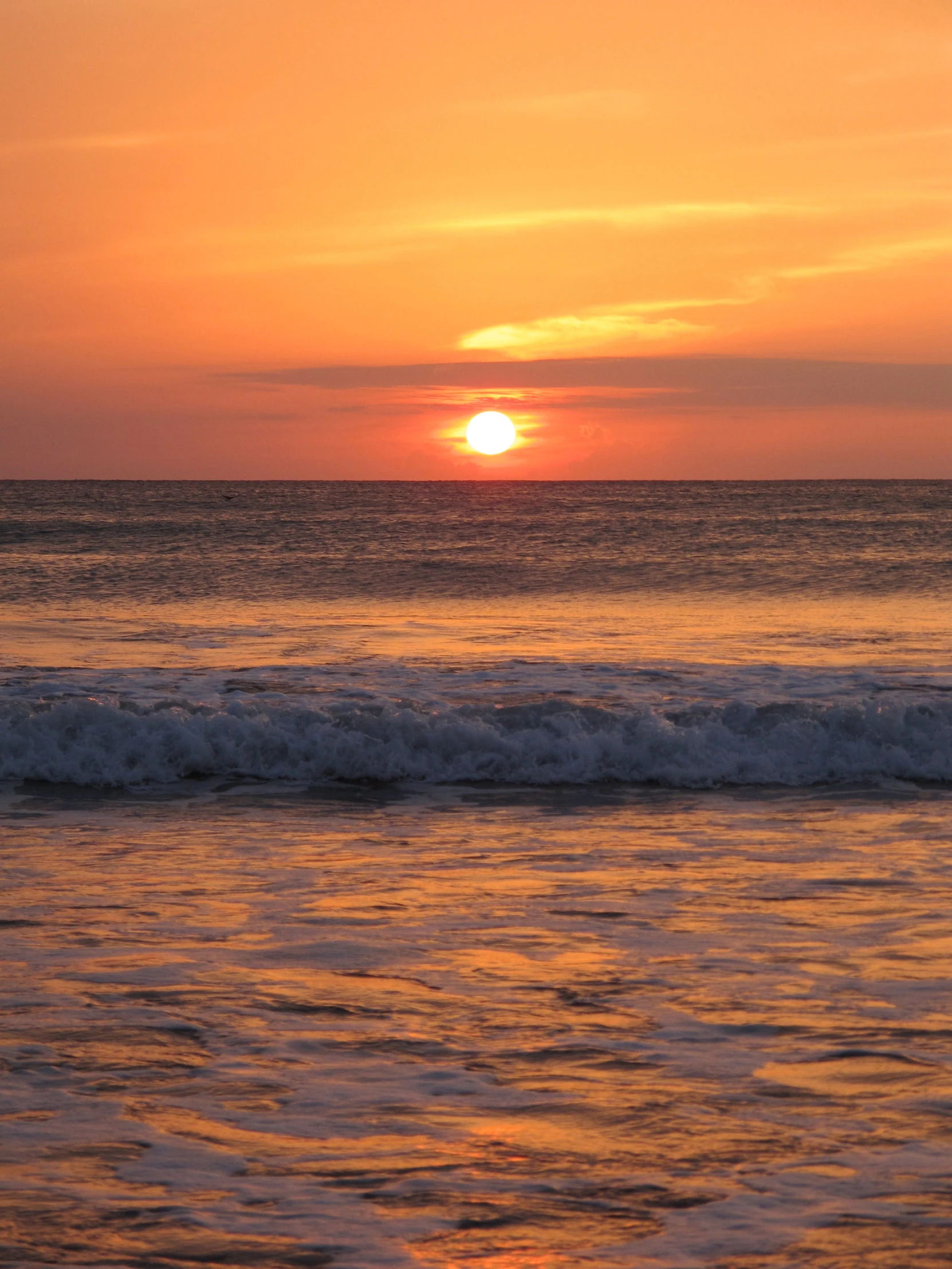 the sun is setting over the ocean waves