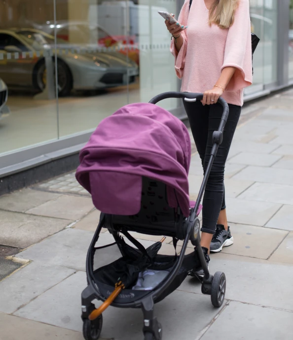 a woman in a pink sweater is using her cell phone