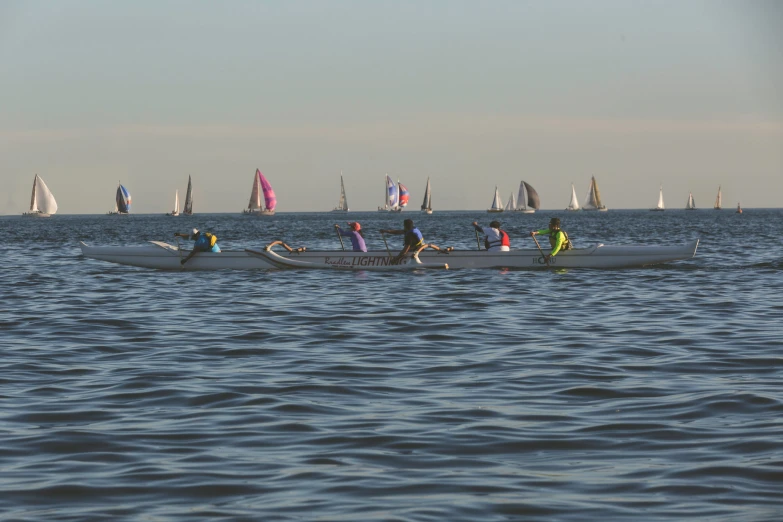 a group of people in a small boat with several smaller boats