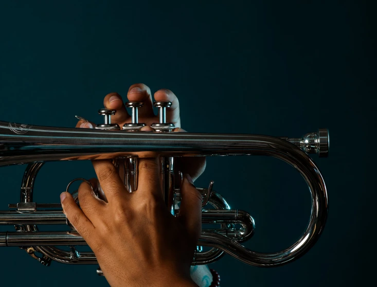 a hand holding onto the ends of a trumpet